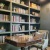Cozy library with bookshelves and comfortable seating inside The Birney Apartments clubhouse